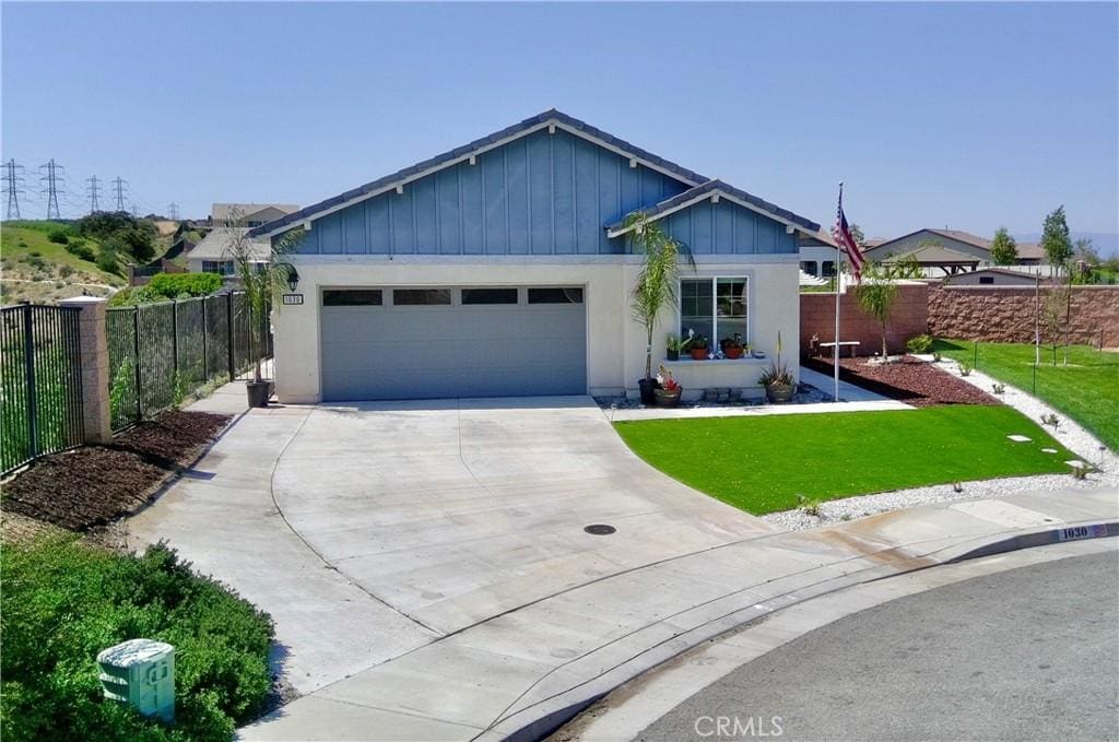 1030 Lavender Ct, Calimesa, CA 92320 - ranch-style house with board and batten siding, a garage, fence, a front lawn, and concrete driveway