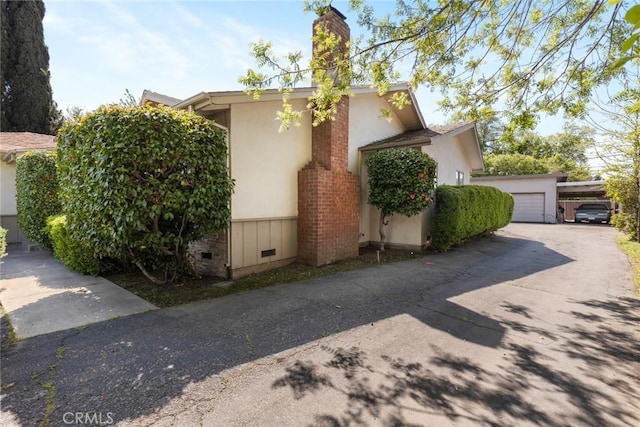 view of property exterior featuring crawl space and a chimney