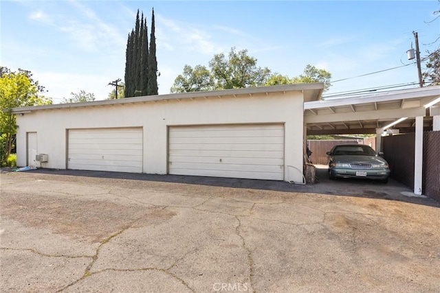 garage featuring fence and a garage