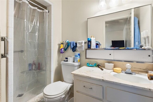 full bathroom with decorative backsplash, toilet, vanity, and a stall shower