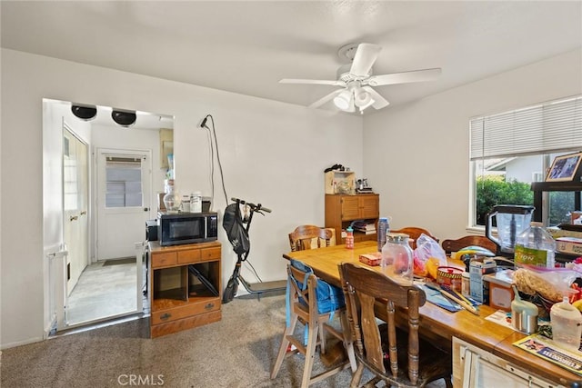 dining space featuring carpet and a ceiling fan
