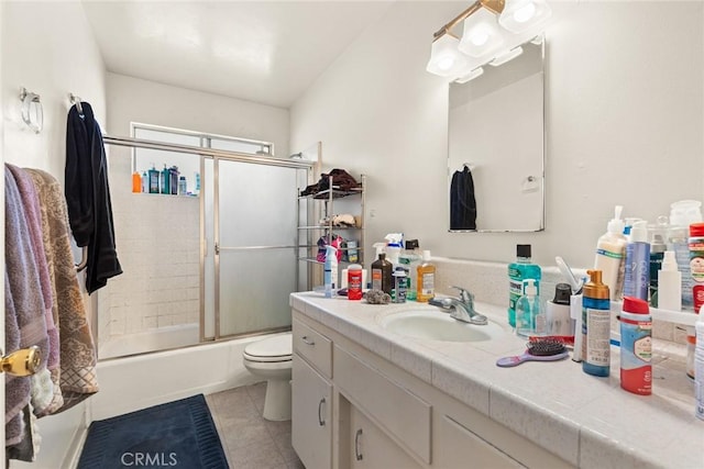 full bath with enclosed tub / shower combo, toilet, vanity, and tile patterned floors
