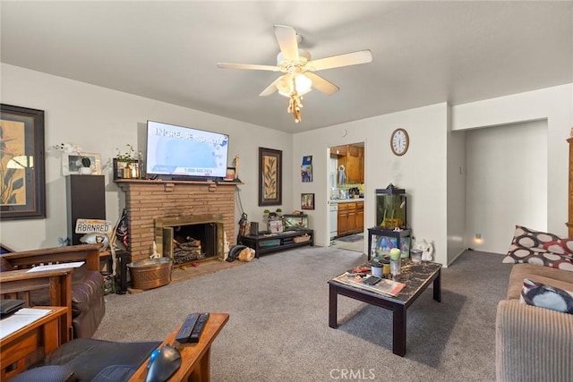 carpeted living area featuring ceiling fan and a stone fireplace