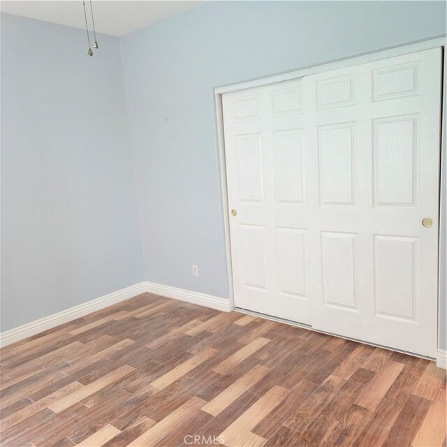 24963 Sunset Vista Ave, Menifee, CA 92584 - unfurnished bedroom featuring light wood-style floors, baseboards, and a closet