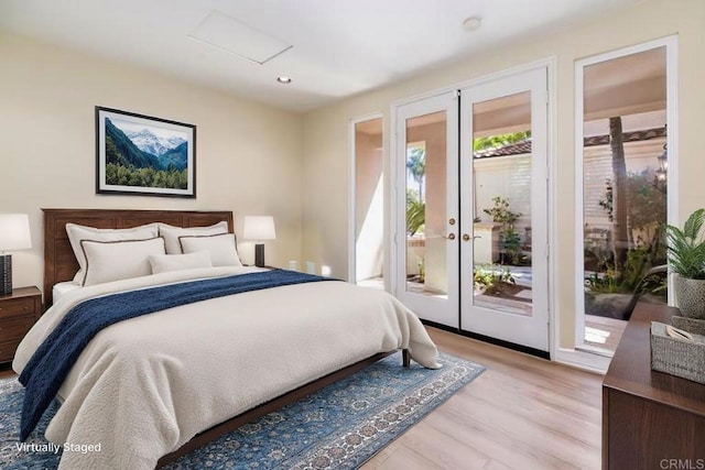 bedroom featuring recessed lighting, light wood-style flooring, french doors, attic access, and access to exterior