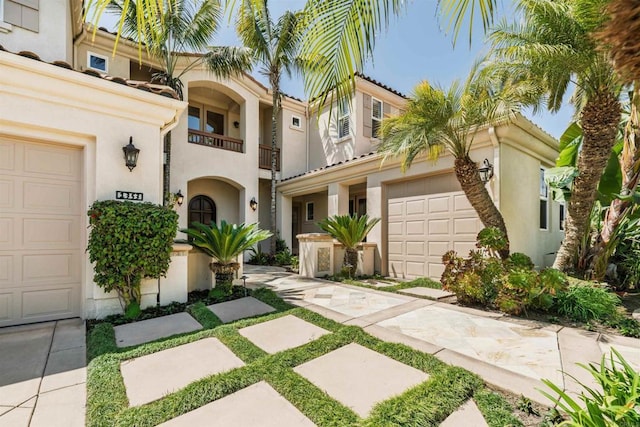mediterranean / spanish-style house with an attached garage and stucco siding
