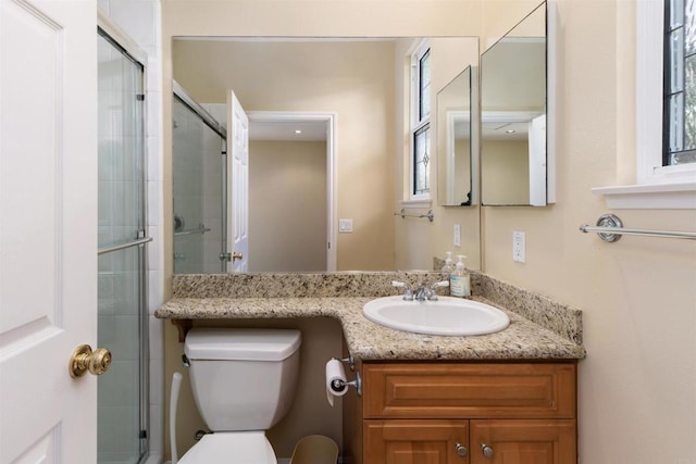 bathroom featuring a tile shower, toilet, and vanity