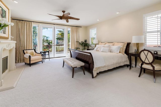 bedroom featuring a ceiling fan, a glass covered fireplace, recessed lighting, access to exterior, and carpet flooring