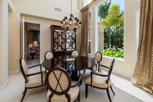 dining space with a healthy amount of sunlight, light colored carpet, a notable chandelier, and visible vents