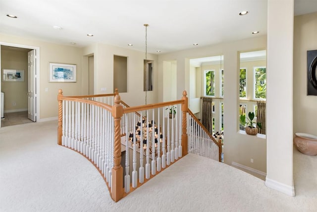 corridor featuring carpet floors, baseboards, an upstairs landing, and recessed lighting