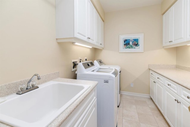 clothes washing area featuring light tile patterned floors, baseboards, washer and dryer, a sink, and cabinet space