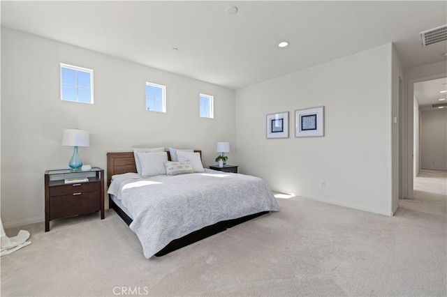 bedroom with visible vents, baseboards, and light carpet