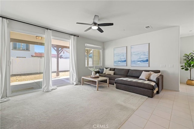 living room featuring light tile patterned flooring, light carpet, ceiling fan, and visible vents
