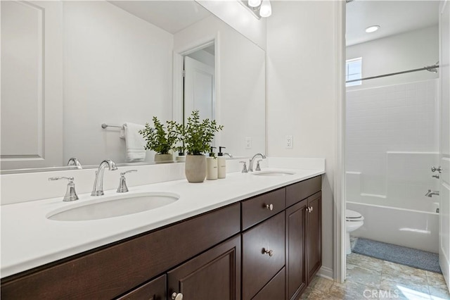 bathroom featuring a sink, toilet, double vanity, and  shower combination