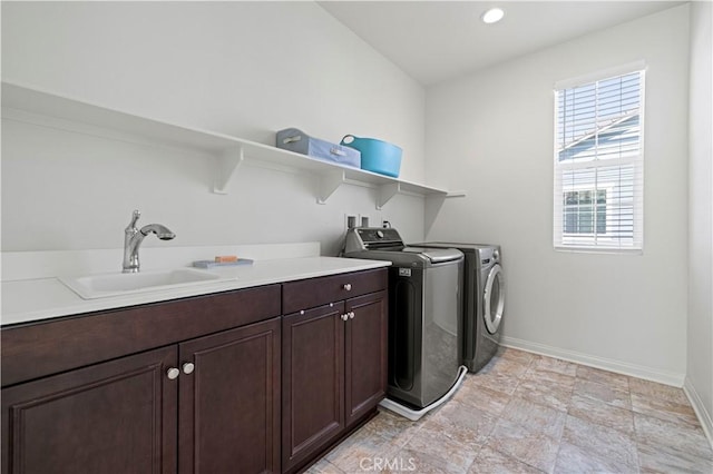 laundry room with baseboards, recessed lighting, washer and clothes dryer, cabinet space, and a sink