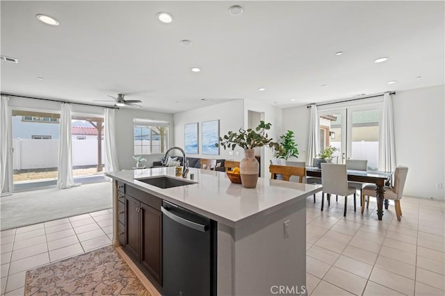 kitchen featuring stainless steel dishwasher, light tile patterned floors, recessed lighting, light countertops, and a sink