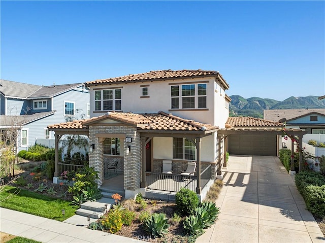 mediterranean / spanish-style home with covered porch, stucco siding, a tile roof, an attached garage, and driveway