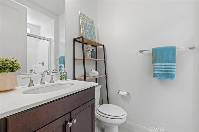 full bathroom with toilet, an enclosed shower, vanity, and baseboards