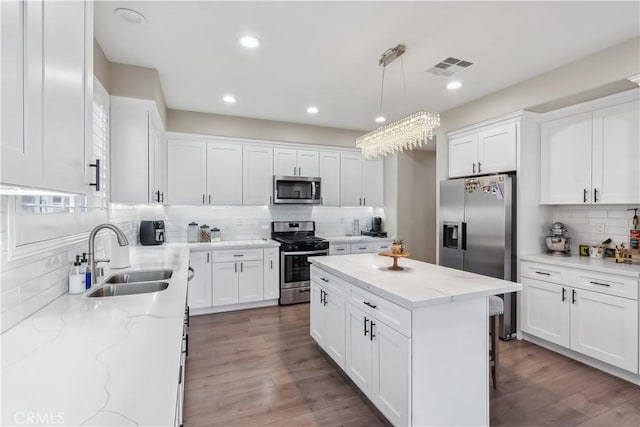 kitchen with visible vents, white cabinetry, a sink, and appliances with stainless steel finishes