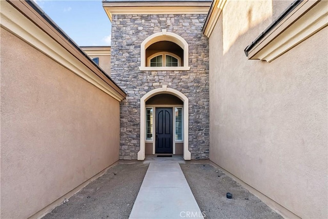 property entrance with stone siding and stucco siding