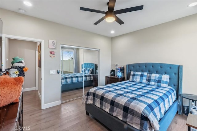 bedroom featuring a closet, baseboards, recessed lighting, a ceiling fan, and wood finished floors