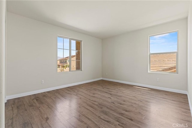 11102 Duran, Jurupa Valley, CA 91752 - empty room featuring baseboards, wood finished floors, and a healthy amount of sunlight