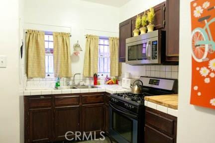 324 W 9th St, Long Beach, CA 90813 - kitchen featuring range with gas stovetop, stainless steel microwave, decorative backsplash, and a sink