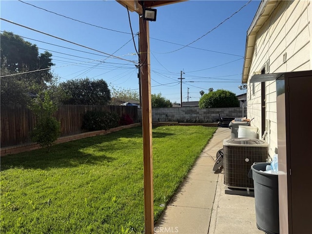 view of yard with central air condition unit and a fenced backyard