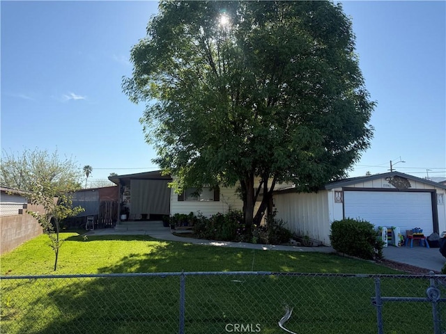view of front facade with a front yard, a fenced backyard, and an outbuilding