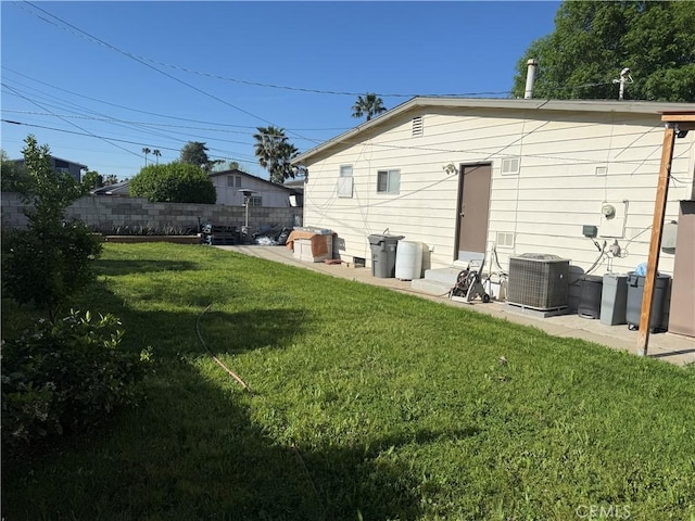 rear view of property featuring a patio area, fence, a lawn, and central air condition unit