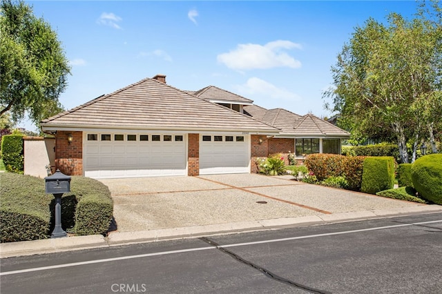 22316 Bear Creek Dr S, Murrieta, CA 92562 - view of front of property with a tile roof, driveway, brick siding, and a garage