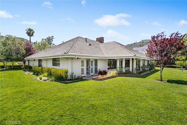 22316 Bear Creek Dr S, Murrieta, CA 92562 - rear view of property with a lawn, a chimney, a tile roof, and stucco siding