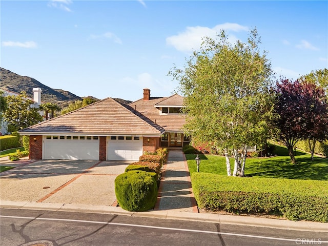 22316 Bear Creek Dr S, Murrieta, CA 92562 - view of front of house featuring a front lawn, driveway, brick siding, a mountain view, and a garage
