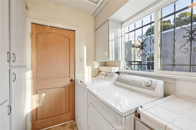 washroom featuring independent washer and dryer and cabinet space