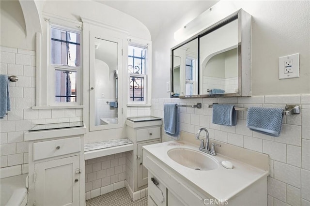 bathroom featuring tile walls, vanity, and wainscoting