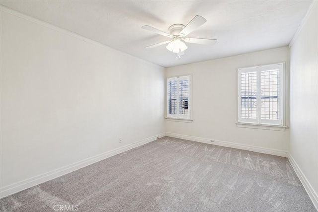unfurnished room with crown molding, light colored carpet, ceiling fan, and baseboards