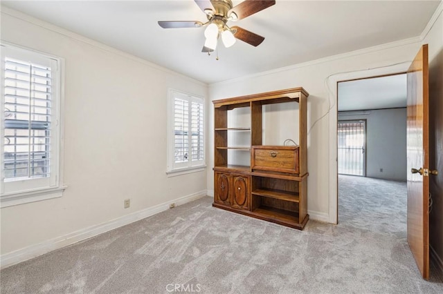 unfurnished bedroom featuring baseboards, multiple windows, ornamental molding, and carpet