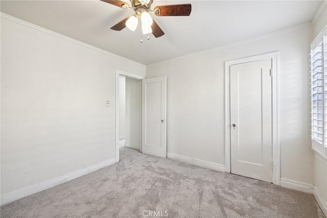 unfurnished bedroom with multiple windows, baseboards, ornamental molding, and carpet floors