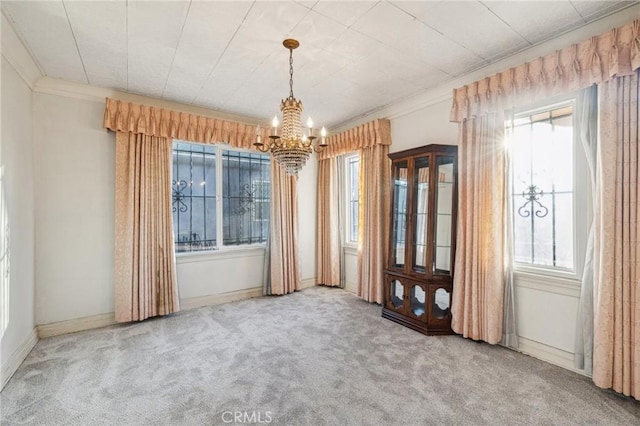 unfurnished dining area featuring baseboards, carpet flooring, and a notable chandelier