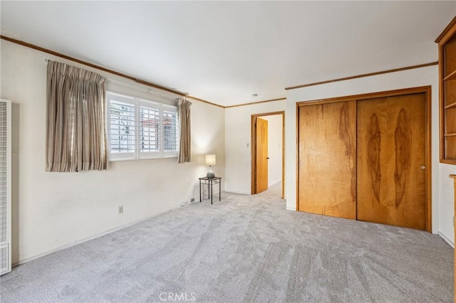 unfurnished bedroom featuring crown molding, a closet, and carpet