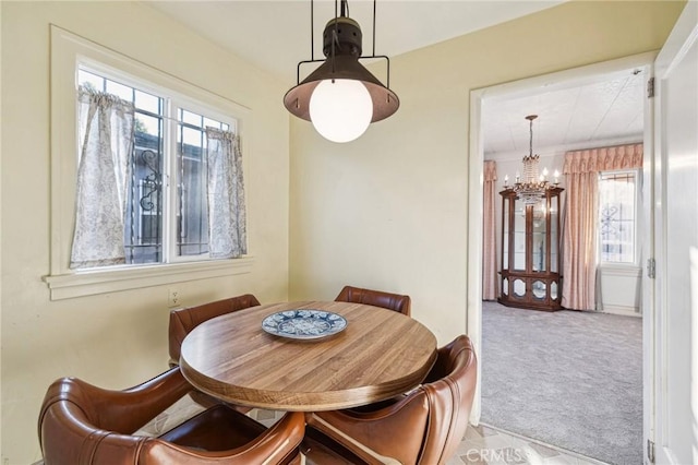 dining room featuring carpet floors, baseboards, and a notable chandelier