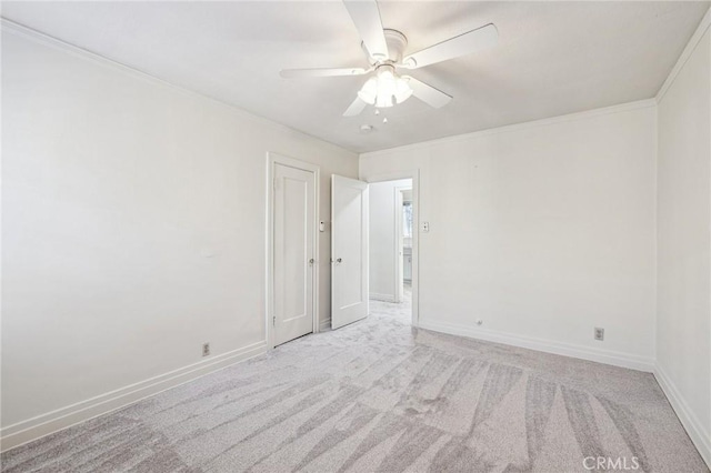 empty room with ceiling fan, baseboards, ornamental molding, and carpet floors
