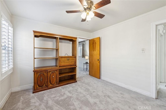 unfurnished bedroom with multiple windows, baseboards, ornamental molding, and carpet floors