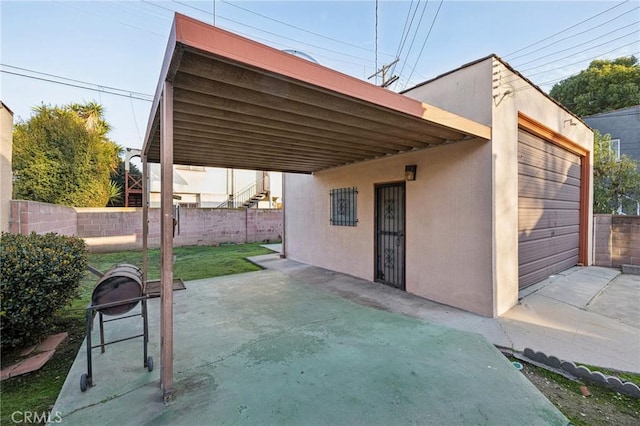 view of patio / terrace with fence and a garage