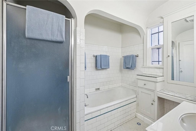 bathroom with vanity, a bath, a stall shower, and lofted ceiling