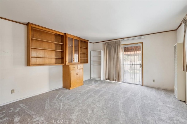 unfurnished living room with light colored carpet and ornamental molding