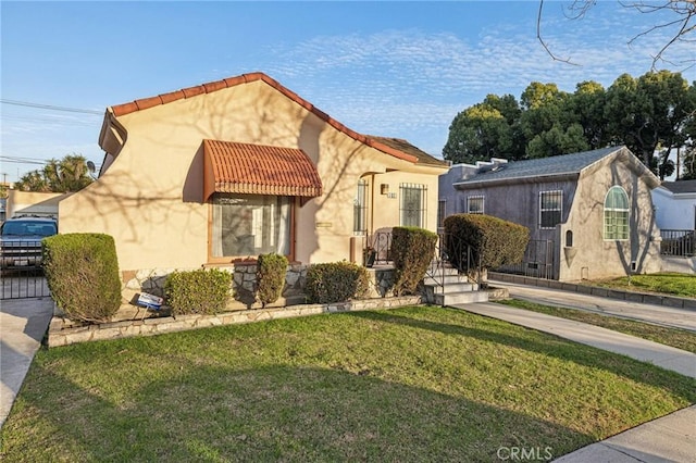mediterranean / spanish home with a front yard and stucco siding