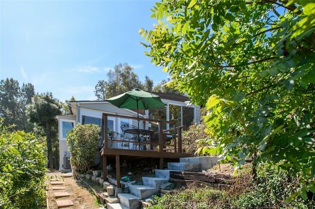 back of house featuring stairs, stucco siding, and a wooden deck