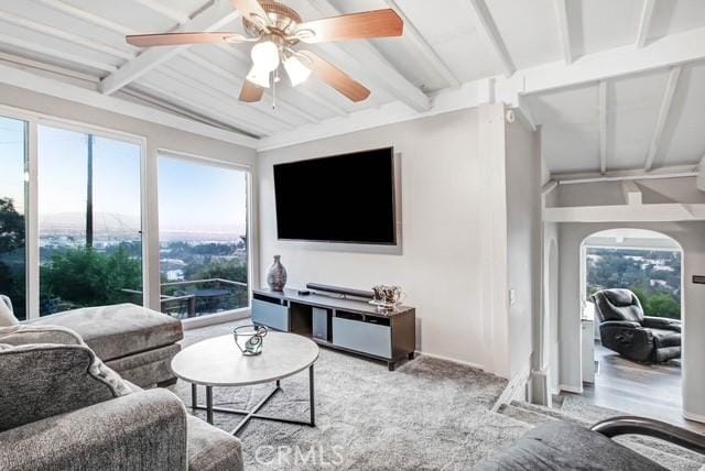 living area with beamed ceiling and ceiling fan