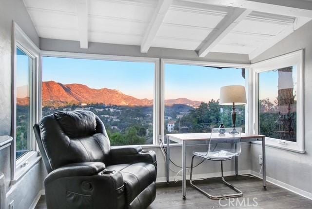 sunroom / solarium featuring a mountain view, beamed ceiling, and plenty of natural light